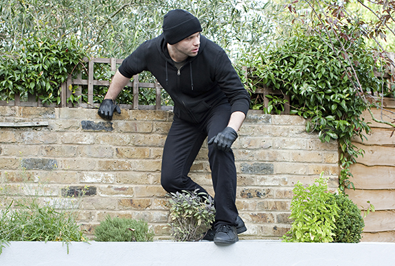 burglar-breaking-in-via-back-yard